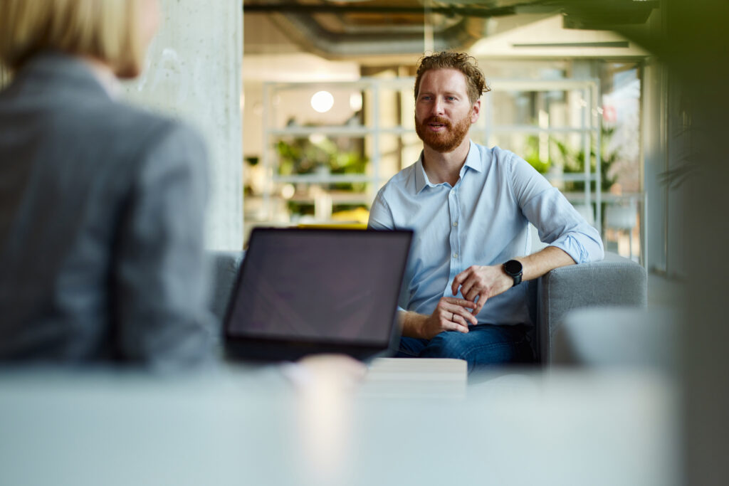 Male customer communicating with his agent while having a casual meeting in the office.